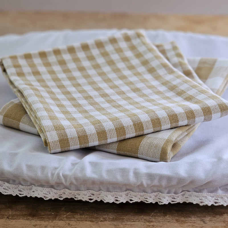 Add rustic farmhouse style to your kitchen with our Golden Wheat Gingham Kitchen Towel Set. Made of 100% cotton, the classic check pattern in a warm golden tan and cream is perfect for adding a charming cottage twist to your home. They're easy to care for, making them perfect for every day use. Set of two. 17"W x 27"H