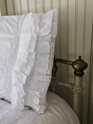 Our Petticoat Eyelet and Ruffles Pillow Sham brings shabby chic and farmhouse style together to create a dreamy white cottage bedroom. This Sham features a double layer of snow-white ruffle edges with exquisite floral eyelet detail and embroidered trim on both ends. This lace edge sham will add texture and a charming vintage look to your room.