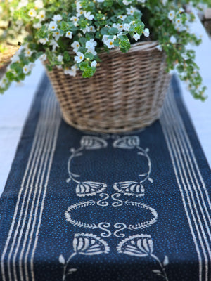 Tuscan Villa Block Print Runner. This table runner features hand-printed cotton, using wood blocks carved with intricate designs. The beautiful design pattern is inspired by old flower art found throughout Europe. The simplicity of the flowers reminds us of warm evenings and friendly dinners. Crafted from hand spun and hand woven organic cotton fabric and then hand dyed in natural dyes.