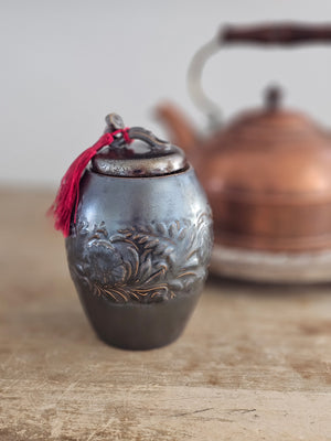 Add an old-world touch to your tea collection with our Embossed Ceramic Tea Canister. Features a unique glaze with a shimmering, translucent&nbsp; brown finish. The intricate embossed floral design makes it a must-have for any shelf. Preserve your tea's freshness and elevate your kitchen decor with this timeless canister. Comes with a red tassel that can also be removed.&nbsp;