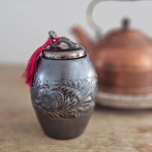 Add an old-world touch to your tea collection with our Embossed Ceramic Tea Canister. Features a unique glaze with a shimmering, translucent&nbsp; brown finish. The intricate embossed floral design makes it a must-have for any shelf. Preserve your tea's freshness and elevate your kitchen decor with this timeless canister. Comes with a red tassel that can also be removed.&nbsp;