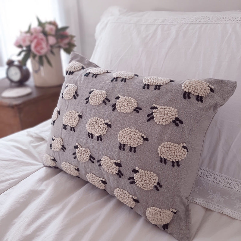 Our Counting Sheep Pillow adds a bit of whimsy and pure country style to your bedroom. This sweet accent pillow features embroidered sheep that look and feel like little woolen clouds against a warm grey background.  100% cotton. Insert included. Dry clean. 16"L x 12"H