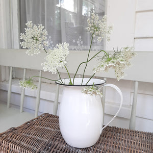 Bring the easy charm of country cottage living to your farmhouse with our Vintage Style Enamel Pitcher with Black Rim. The simple allure of enamelware fits right in with any decor, but every farmhouse needs at least one piece. Inspired by flea market finds, our white enamel pitcher has black trim and makes the perfect vase for your favorite bouquet. Not food safe. Pitcher measures 6¼" high by 5¼" diameter (7" wide with handle).
