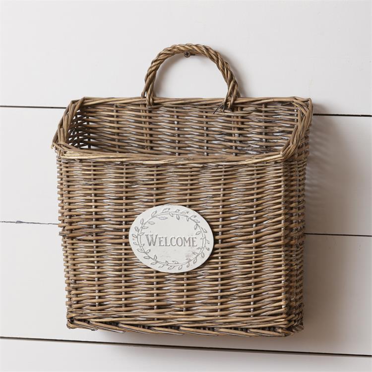 The Welcome Wicker Wall Basket is ready to greet guests with a cheerful country hello. Fill it with flowers for a bright and cheerful entryway or use it t collect mail on a farmhouse porch.  12”L  5"W x 13”H