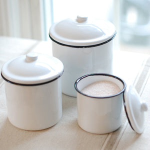 This set of three White Enamel Canisters with Black Trim has nostalgic charm, reminiscent of grandma's kitchen. The set's retro style is perfect for farmhouse kitchens, and features distressed white enamel with black trim. Canisters are food, oven and dishwasher safe.