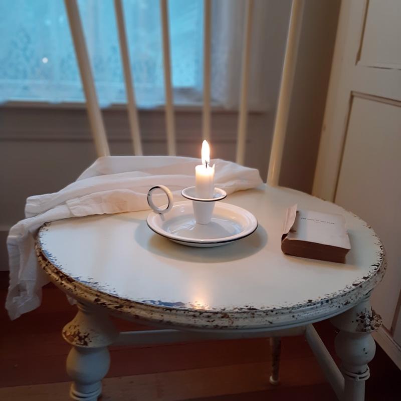 Add that centuries old farmhouse look to any bedside bureau or tabletop with our White Chamberstick Taper Candle Holder. It has the classic finger loop and tray, which made it easy to carry candles from room to room back in the day. The white enamel finish adds a sweet cottage feel. Taper candle not included.  5"W x 2½"H