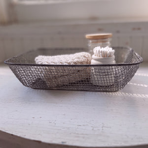 Our Wire Tray Basket offers quintessential vintage farmhouse style. This charming shallow wire basket is perfect for berries and fruit or for mail and more. This antique inspired wire mesh tray basket features a weathered metal finish with hints of chippy white paint. Makes a beautiful presentation for farmhouse gatherings to hold napkins or add it to your home office. Accessories not included. 11"L x 8.5”W x 2.5"H