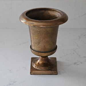 The Aged Bronze Gold Metal Urn Vase adds antique style to any tabletop. It features an old-world look with a timelessly aged feel. Crafted from metal, this vase is perfect for decorating any living space. 
