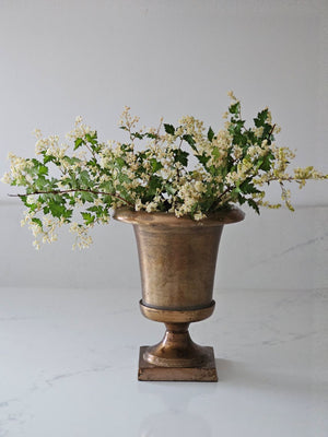 The Aged Bronze Gold Metal Urn Vase adds antique style to any tabletop. It features an old-world look with a timelessly aged feel. Crafted from metal, this vase is perfect for decorating any living space. 