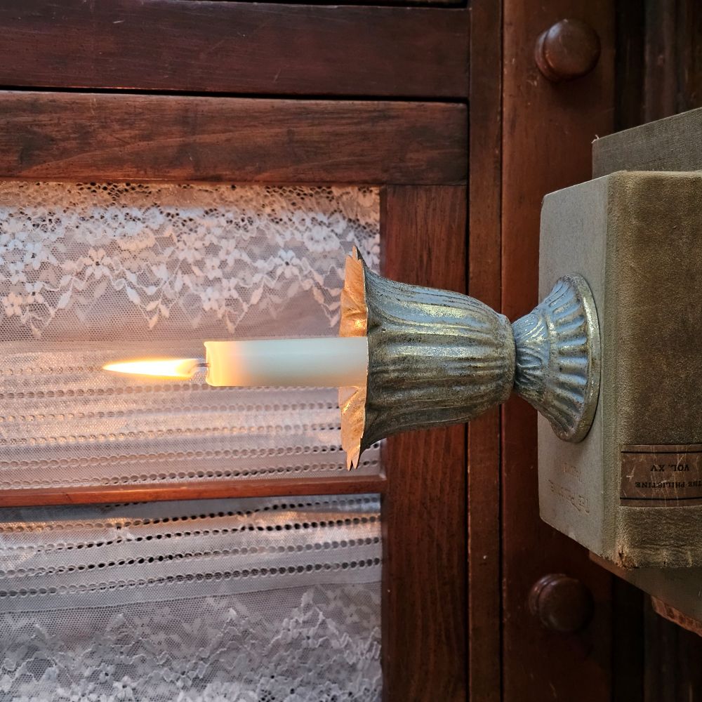 Our Aged Gold Fluted Urn Taper Candle Cup features a distressed gold metal finish with an ornate scalloped design. The cup sits on a pedestal and has plenty of space between the holder and the sides, making it the perfect choice for displaying a candle ring! The candle cup has vintage style and is ideal for catching dripping wax. Measures 3.75" in diameter and 4"H and holds a standard taper (candle not included).