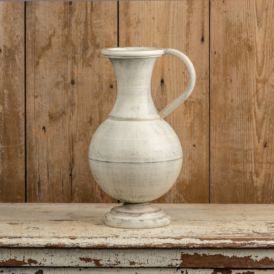 This eye-catching Aged White Pitcher Vase has the allure of found treasures.  It's long graceful neck and footed base give it a touch of elegance for any modern farmhouse. Its neutral, faded hue makes it perfect for showcasing your favorite floral arrangements. 10"L x 8.75W x 15.50"H