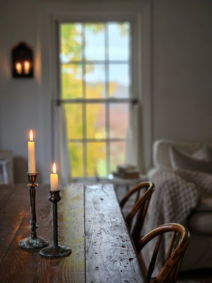 This Aged Brass Finish Taper Candle Holder Set brings timeless style to any tabletop. The old brass style finish has a time-worn patina, inspired by antique shop finds. This set of two features different style necks, both with a slender, elegant design. Add to a bookshelf, bedside table, or create a stunning centerpiece on a long farm table by weaving a few among a garland of greenery. Candles not included.