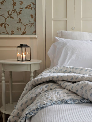 Add a cheerful touch of sweet cottage style to your guest room or reading nook with this Block Print and Ruffles Double-Sided Throw Blanket. Each side has a different block print design in a soft hue that creates a tranquil feel. Finished with a ruffled edge, this cozy quilted throw is crafted of 100-percent cotton and is machine washable for easy care. 40”W x 60”H
