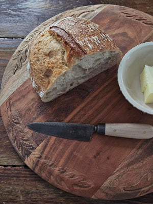 Bring the warmth and character of aged wood into your home with our Antique Style Wood Bread Board. Made of acacia wood, this serving board features beautiful hand-carved leaf designs around the edges. They make a beautiful and functional accent piece for any home. They can be used as a serving board,charcuterie board, cutting board, trivet, and more