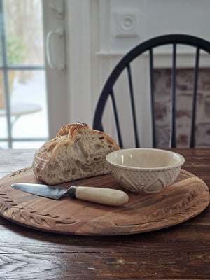 Bring the warmth and character of aged wood into your home with our Antique Style Wood Bread Board. Made of acacia wood, this serving board features beautiful hand-carved leaf designs around the edges. They make a beautiful and functional accent piece for any home. They can be used as a serving board,charcuterie board, cutting board, trivet, and more