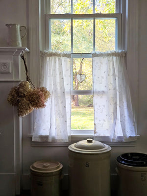 Dress up any window in breezy cottage charm with the Antique White Lace Cafe Curtains. With a creamy, off-white cotton, this semi-sheer curtain tier set features a floral eyelet and embroidered pattern of little sprigs to update your home decor with a lighthearted country feel. Whether you're going for a coastal, cottage our country look, these cafe curtains add the perfect combination of simplicity and elegance 
