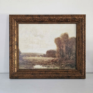Our Antiqued Bronze Frame with Autumnal Landscape Print adds a moody, vintage touch to any room. The frame holds an 8 x 10 image and can be hung or used on a tabletop, both vertically or horizontally. Made of PS material, the frame features a wood-like feel, but is much lighter. Features detailed molding and an aged bronze finish. Includes glass and fits 8 x 10 prints. The Autumnal Landscape Print features golden green hues and depicts a quiet tree-lined meadow.