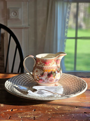 The Antique Style Old World Floral Pitcher brings a touch of elegance and vintage romance to any occasion. This porcelain pitcher features a richly detailed floral design, highlighted by a warm, cream-toned glaze that gives the piece a soft, antique-inspired appearance. The base color is not a bright white, but rather a subtle ivory/cream tone that enhances the depth and character of the intricate floral artwork and ornate border detailing.