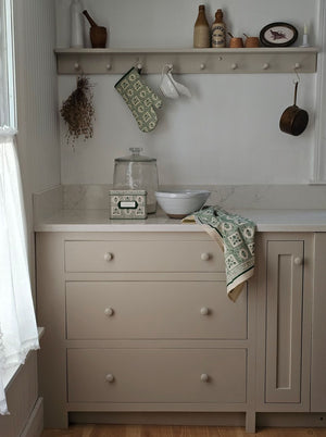 Bring timeless cottage elegance to your kitchen with the Artichoke Oven Mitt. Showcasing a vintage-inspired green artichoke motif against an ivory backdrop, it is accented with contrasting piping and a convenient corner loop for easy hanging. This quilted mitt offers reliable heat protection while enhancing your kitchen decor with refined charm. 100% cotton with polyester batting.