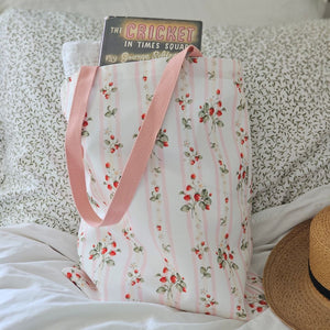The Bespoke Strawberries and Stripes Tote Bag is perfect for groceries, shopping excursions at the farmers market or a day at the beach. This cotton canvas tote features a vintage-inspired strawberry design with sweet pink stripes and a pink handle. Made in England, the bespoke design is created with a love of color, heritage and intricate design while celebrating craftsmanship, storytelling and a strong sense of seasonality.