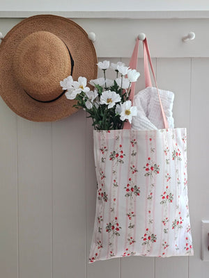 The Bespoke Strawberries and Stripes Tote Bag is perfect for groceries, shopping excursions at the farmers market or a day at the beach. This cotton canvas tote features a vintage-inspired strawberry design with sweet pink stripes and a pink handle. Made in England, the bespoke design is created with a love of color, heritage and intricate design while celebrating craftsmanship, storytelling and a strong sense of seasonality.