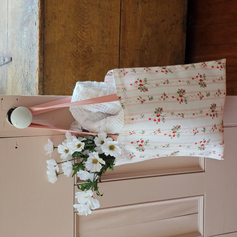 The Bespoke Strawberries and Stripes Tote Bag is perfect for groceries, shopping excursions at the farmers market or a day at the beach. This cotton canvas tote features a vintage-inspired strawberry design with sweet pink stripes and a pink handle. Made in England, the bespoke design is created with a love of color, heritage and intricate design while celebrating craftsmanship, storytelling and a strong sense of seasonality.
