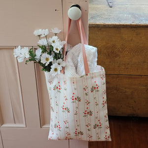 The Bespoke Strawberries and Stripes Tote Bag is perfect for groceries, shopping excursions at the farmers market or a day at the beach. This cotton canvas tote features a vintage-inspired strawberry design with sweet pink stripes and a pink handle. Made in England, the bespoke design is created with a love of color, heritage and intricate design while celebrating craftsmanship, storytelling and a strong sense of seasonality.
