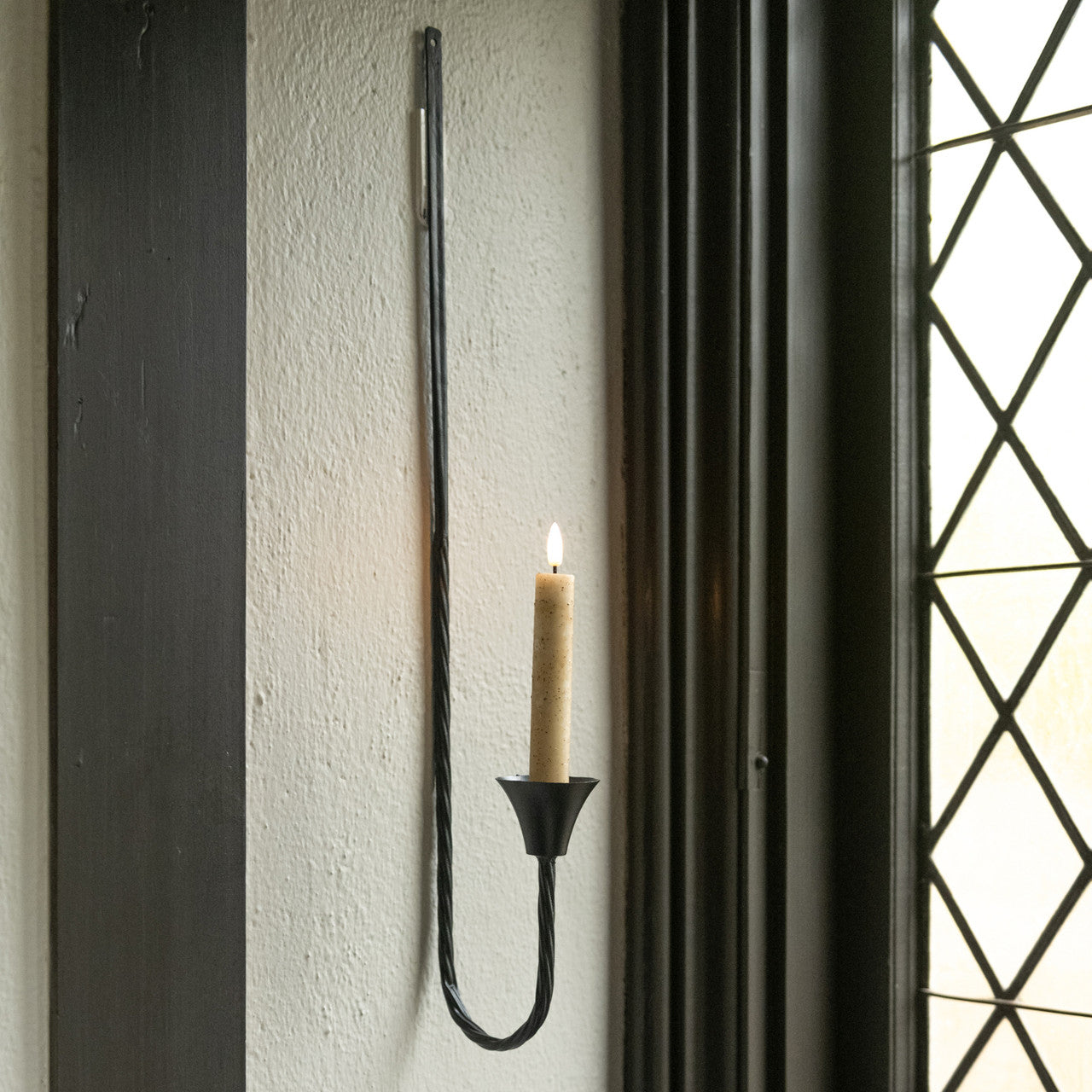 Our rustic style taper candle holder looks as though it was hand-forged at an old blacksmith shop from the 1800s. This slender, forged iron wall sconce features minimalist design with a twist design at the base. The Blacksmith Forged Taper Candle Wall Sconce with Twist Design has distressed character and fits easily with most decor styles.