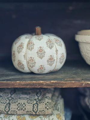 Decorative pumpkin with floral patterns on a wooden shelf