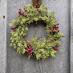  our small faux Boxwood and Berries Wreath and Candle Ring brings a fresh, earthy style to your farmhouse decor. Features faux green boxwood leafs and burgundy berries on a natural wood vine frame.  Evergreen wreath