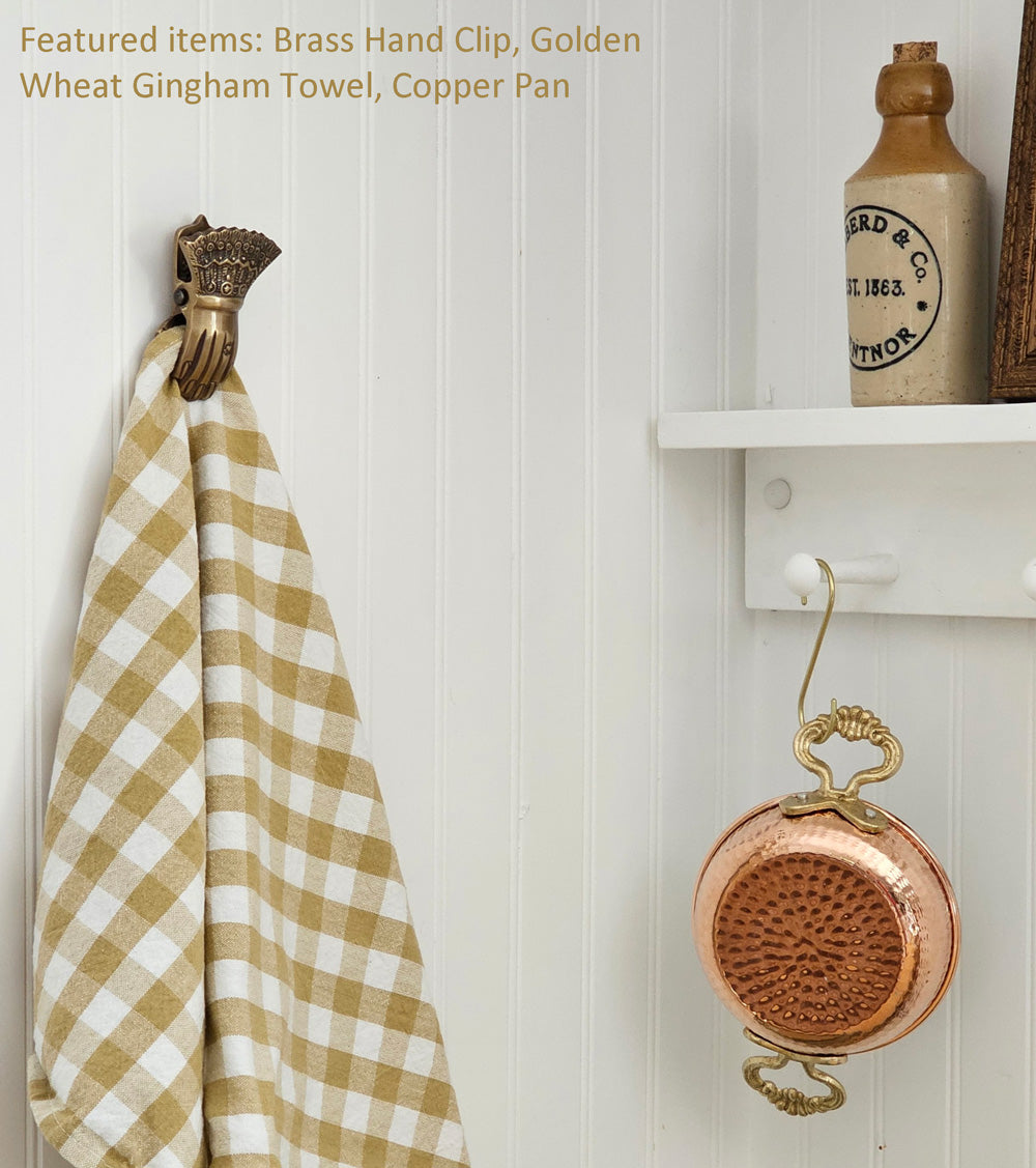 https://farmhousewares.com/cdn/shop/files/Brass-Hand-Clip-with-Golden-Wheat-Gingham-and-Copper-Pan-TXT_24c73723-f73b-4b38-b51e-d938c0b6236f_2048x.jpg?v=1689341573