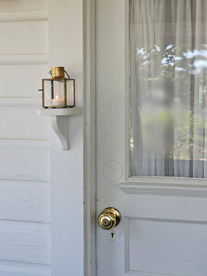 Bring the warmth of flickering candlelight to your home or garden with our Bristol Brass Tealight Lantern. The antique brass style finish offers a coastal cottage feel with old-world charm. The glass windows protect the flame. Includes a door on one side and a wire handle for hanging.