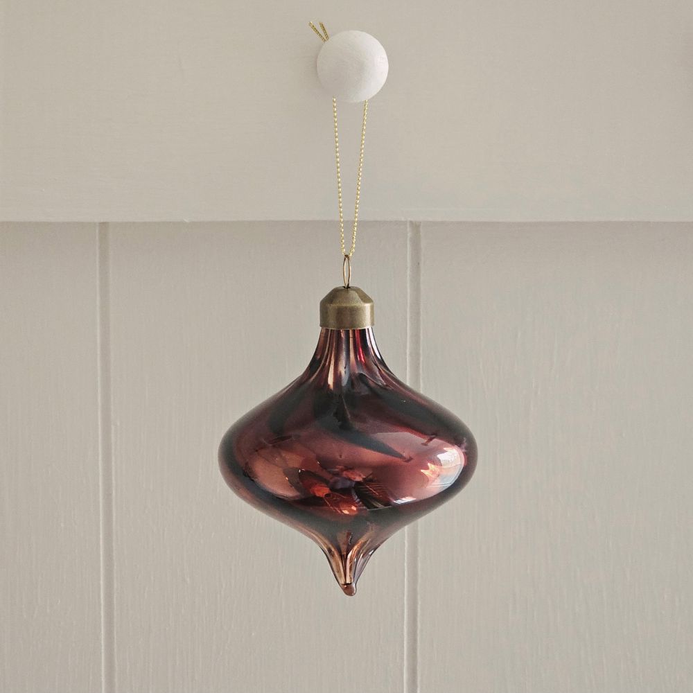 Add ambiance to your holiday display with this exquisite Bronze Glass Teardrop Ornament crafted from warm red-brown glass that catches the light with understated elegance. The subtle swirl pattern adds visual depth, while the antiqued brass cap provide a refined finishing touch.
