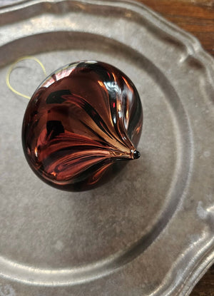 Add ambiance to your holiday display with this exquisite Bronze Glass Teardrop Ornament crafted from warm red-brown glass that catches the light with understated elegance. The subtle swirl pattern adds visual depth, while the antiqued brass cap provide a refined finishing touch.