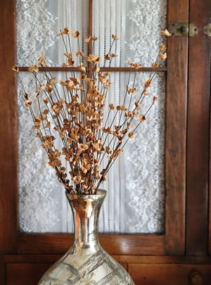 Our airy Brown Branch and Tea Stained Blossom Bush adds warm color and interest to your displays all year round. The wispy branch and delicate tea stained fabric blossoms lend easy country cottage charm. Display alone for a simple country look or arranged into a bouquet.