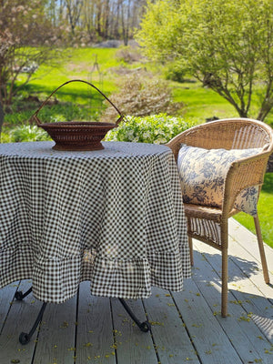Enhance any occasion with the Brown and White Gingham Check Tablecloth with Ruffled Edge, where timeless country charm meets refined design. This durable and easy-care tablecloth sets the scene for countryside gatherings. The classic gingham pattern combined with the ruffled edge creates a sweet, vintage look no matter the season. Cotton/polyester blend. Available in two sizes: 72" Round and 56" x 120" Rectangle