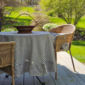Enhance any occasion with the Brown and White Gingham Check Tablecloth with Ruffled Edge, where timeless country charm meets refined design. This durable and easy-care tablecloth sets the scene for countryside gatherings. The classic gingham pattern combined with the ruffled edge creates a sweet, vintage look no matter the season. Cotton/polyester blend. Available in two sizes: 72" Round and 56" x 120" Rectangle
