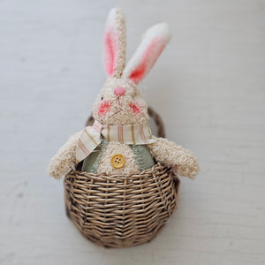 The Bunny in a Basket adds a sweet spring touch to any room. Each bunny features soft chenille fabric, blushed cheeks, posable ears, and wooden buttons. The girl bunny wears a pink fabric dress with a plaid bow and headband, while the boy bunny wears a green fabric vest with a plaid necktie. Can be used with or without the mini wall basket. Bunny measures 5.5" high by 3" wide.