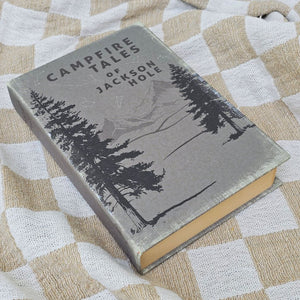 Inspired by antique bookshop finds, our Hardcover Book Journal, Campfire Tales is like snuggling up with an old book, only this time, you get to be the author. Features a faded hardcover and discolored paper pages. It's infused with vintage charm. Like old books, the pages of this journal have an aged warmth and have lines for neat note keeping. The binding also has an old book feel and the cover features a vintage graphic with the title, "Campfire Tales." 5.75"L x 1.25"Deep X 8.5"H