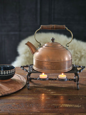 The Cast Iron Pot Warmer Trivet is perfect for adding an old-time touch with tons of practicality. This rectangular cast iron trivet is designed to keep teapots and food dishes warm. It features two tea light candle holders under the grill and an antique brown finish.