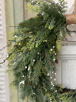 The White Berry and Cedar Wreath brings a quiet elegance to any room. Beautiful mixed greenery is interspersed with constellations of small white orbs and pine cones to create a collection perfect for season-long use. The twine wrap along the top adds a down-to-earth, rustic touch. 24"