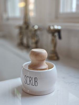 Keep your dish scrub brush neatly organized with our Ceramic Scrub Brush Holder with Brush. Made of crisp white ceramic with black embossed lettering, this holder not only adds a touch of style to your sink, but also keeps your brush within reach for quick and easy cleaning. Say goodbye to cluttered counters and hello to a convenient sink-side solution. Comes with one wood dish scrub brush. Holder is 3.25" diam x 2.25"H, Brush is 2.25" diam x 3.25"H