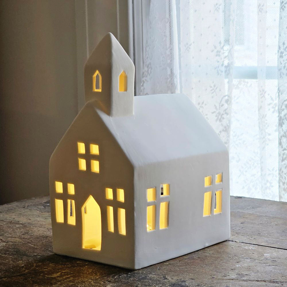 Create magical displays and add warmth to your home with our Lighted Ceramic Church. This tabletop church has a quiet elegance with an organic, minimalist design. The little white church looks beautiful even when not glowing with the warm LED light. Perfect for traditional or modern farmhouse decor.