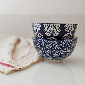 The Cordelia Blue and White Bowls evoke the feeling of vintage finds from the European countryside. These ceramic bowl feature classic blue and white designs. The sapphire blue glaze is etched with a floral design, revealing the cool white under-layer. The etching gives it an embossed, textured feel. These bowls are perfect for small servings of ice cream, rice and more. The set of includes two different floral patterns: small floral and block print style. Food safe. 