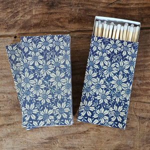 These stylish wood matches, in a sweet Blue Daisy Box, are the perfect complement to any space. Modern, chic, with a vintage graphic design, they are perfect for any room. The match striker is side of the box for easy lighting. Safety matches, 50 sticks per box. Includes set of three boxes. Each is 4.25" x 2.25" x .75"