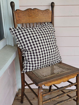 Enhance your living space with the Dark Brown Gingham Pillow, where timeless country charm meets refined design. Crafted from 100% cotton with a subtle off-white and dark brown gingham pattern, this pillow features elegant fringe edging and a discreet, easy-to-remove zipper. Its plush polyester insert offers both comfort and structure, making it a sophisticated accent that brings warmth and texture to any room. Spot clean only to preserve its quality. Measuring 18" x 18"