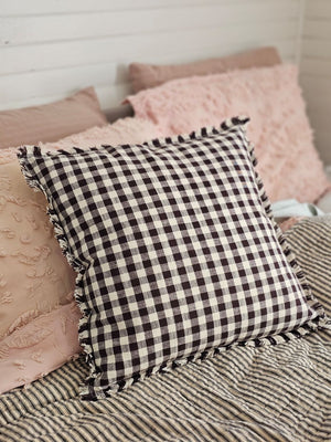 Enhance your living space with the Dark Brown Gingham Pillow, where timeless country charm meets refined design. Crafted from 100% cotton with a subtle off-white and dark brown gingham pattern, this pillow features elegant fringe edging and a discreet, easy-to-remove zipper. Its plush polyester insert offers both comfort and structure, making it a sophisticated accent that brings warmth and texture to any room. Spot clean only to preserve its quality. Measuring 18" x 18"