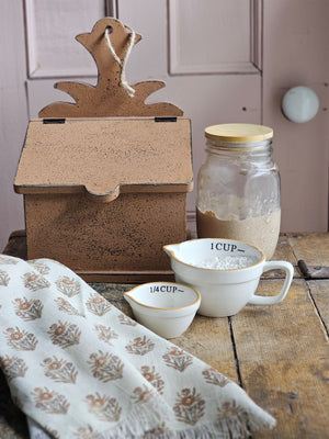 The Distressed Primitive Recipe Box brings a timeless, rustic charm to your kitchen decor. Adorned with a pineapple cutout and equipped with a pre-drilled hole and jute string, it offers flexible display options. Its colonial brown mustard finish, accented by subtle dark wood undertones, creates an authentic antique appeal. This elegant wooden box is perfect for organizing recipe cards (not included) or small keepsakes. 