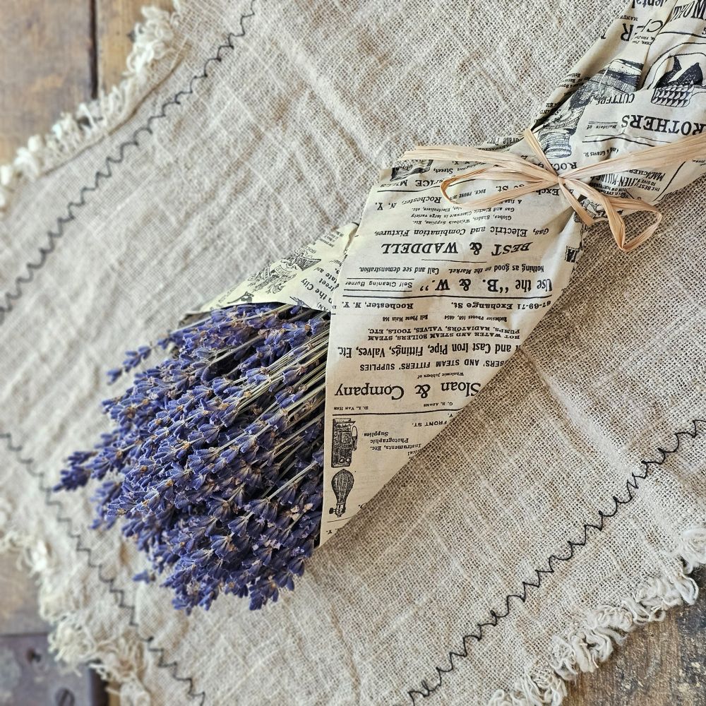 Our French Lavender Bouquet is a nod to the timeless elegance of the French countryside. This Super Blue Lavender is cultivated by generations of passionate French farmers. Each 80-gram bunch stands as a testament to tradition and quality. Wrapped in newsprint tissue paper that resonates with nostalgia, this lavender is a journey back in time. Hand-wrapped and graced with a natural raffia bow, it's more than just lavender; it's a piece of history. Each bundle is approximately 14" long. Made in France.