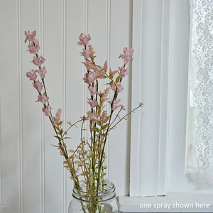 Farmhouse cottage style is made easy with our Dusty Pink Wildflower Spray. This faux flower spray features fabric petals in vintage pink and green leaves on a plastic green stem. The stem is long, slender, and flexible and is easily shaped for a desired look. It can be displayed alone for a simple pop of color or arranged into a bouquet. It easily fits into baskets, buckets, and milk cans and more. Can be trimmed at stem if needed. Includes one pick. 22”H